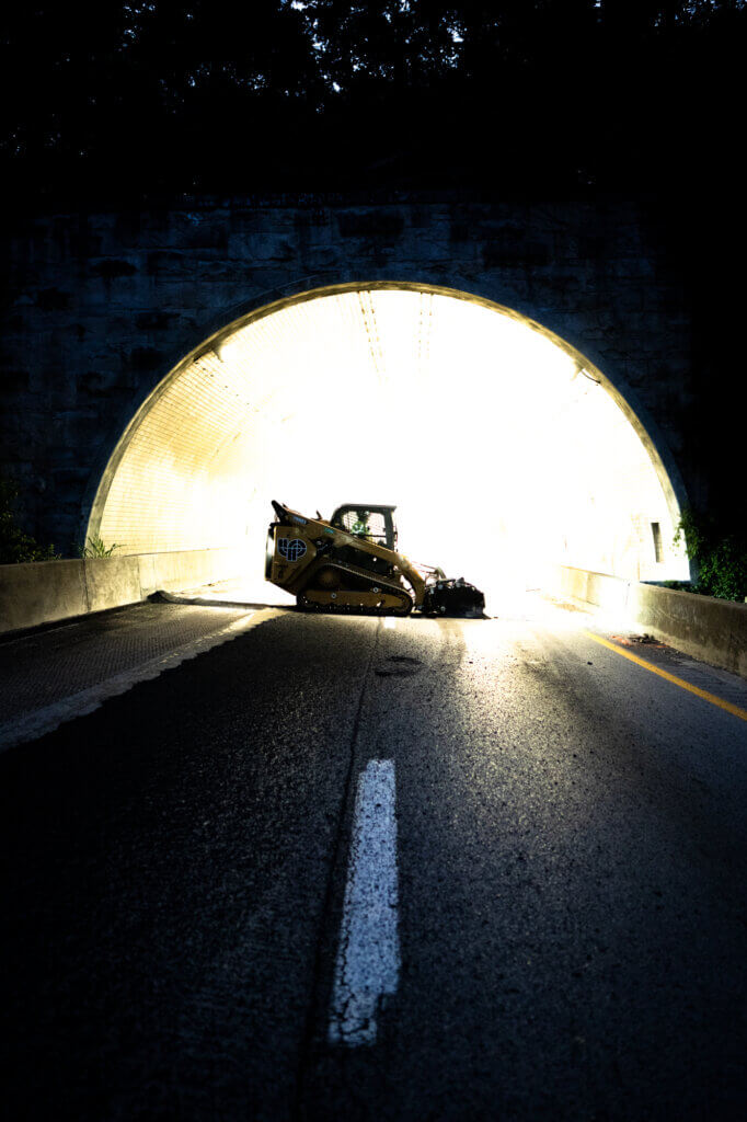 Silhouette of construction bobcat in tunnel